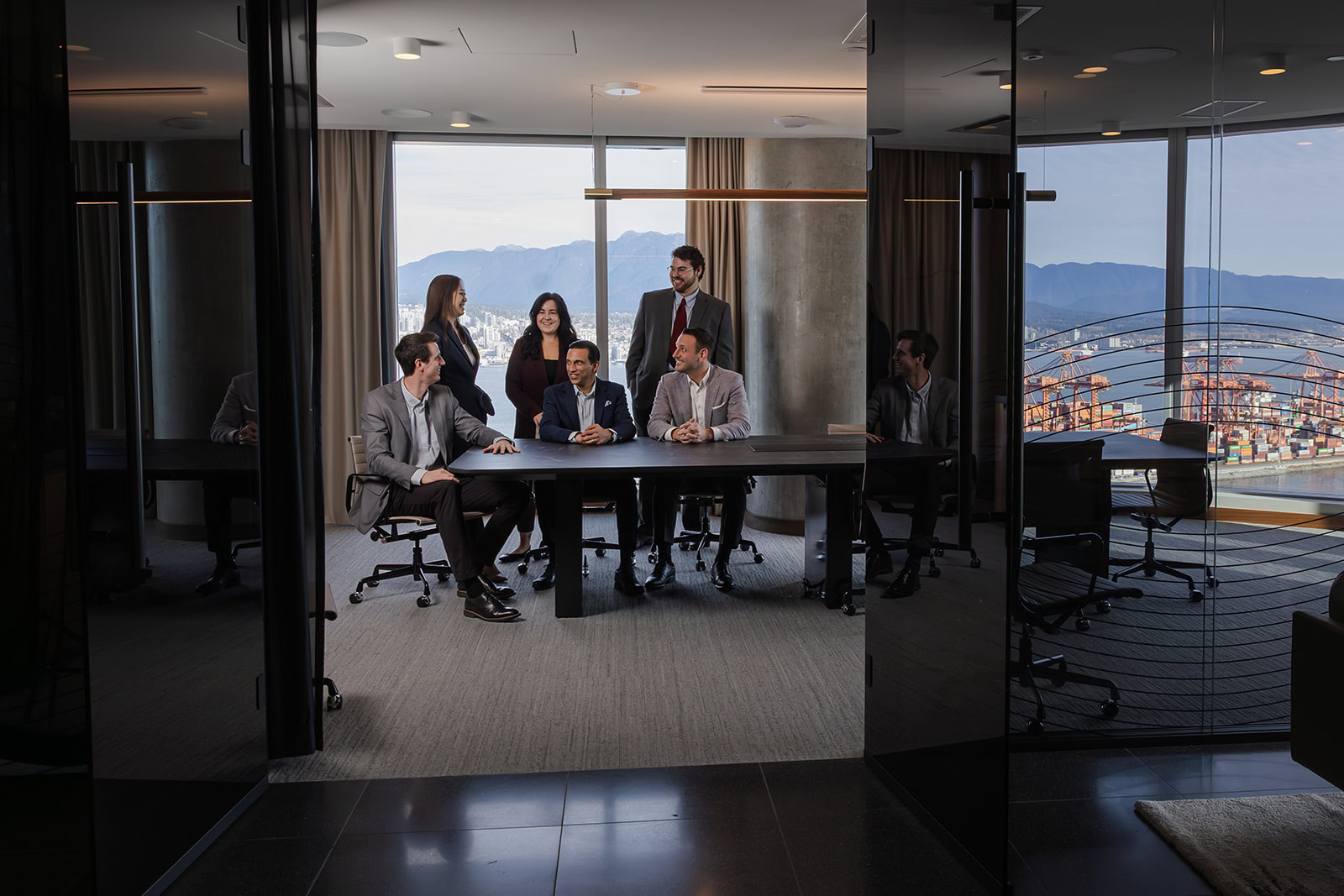 Six advisers at Safe Pacific Financial discuss wealth management, infinite banking, and bespoke Canadian life insurance policies in a bright office.