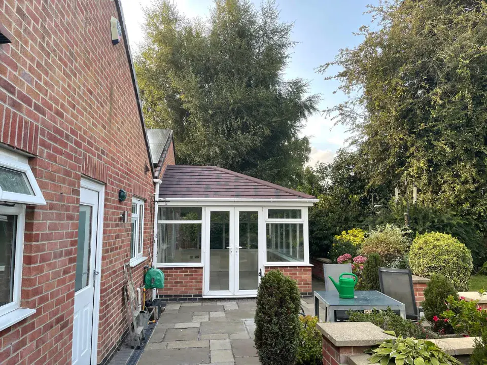 brick conservatory with white framed doors and windows