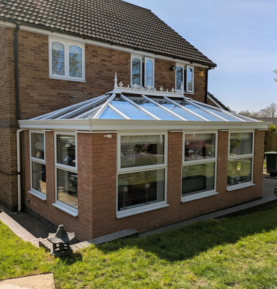 brick conservatory with multiple white framed windows