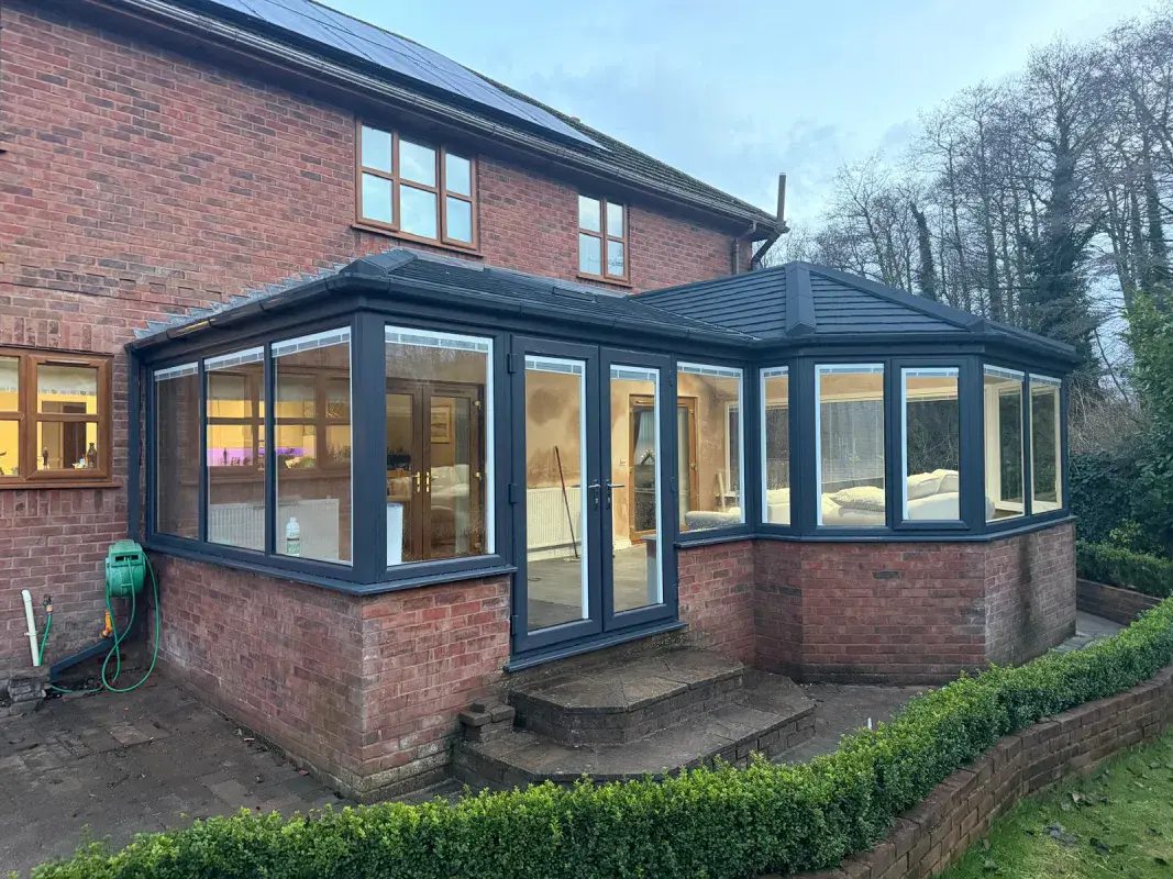 black framed doors and windows placed within the old red bricks conservatory
