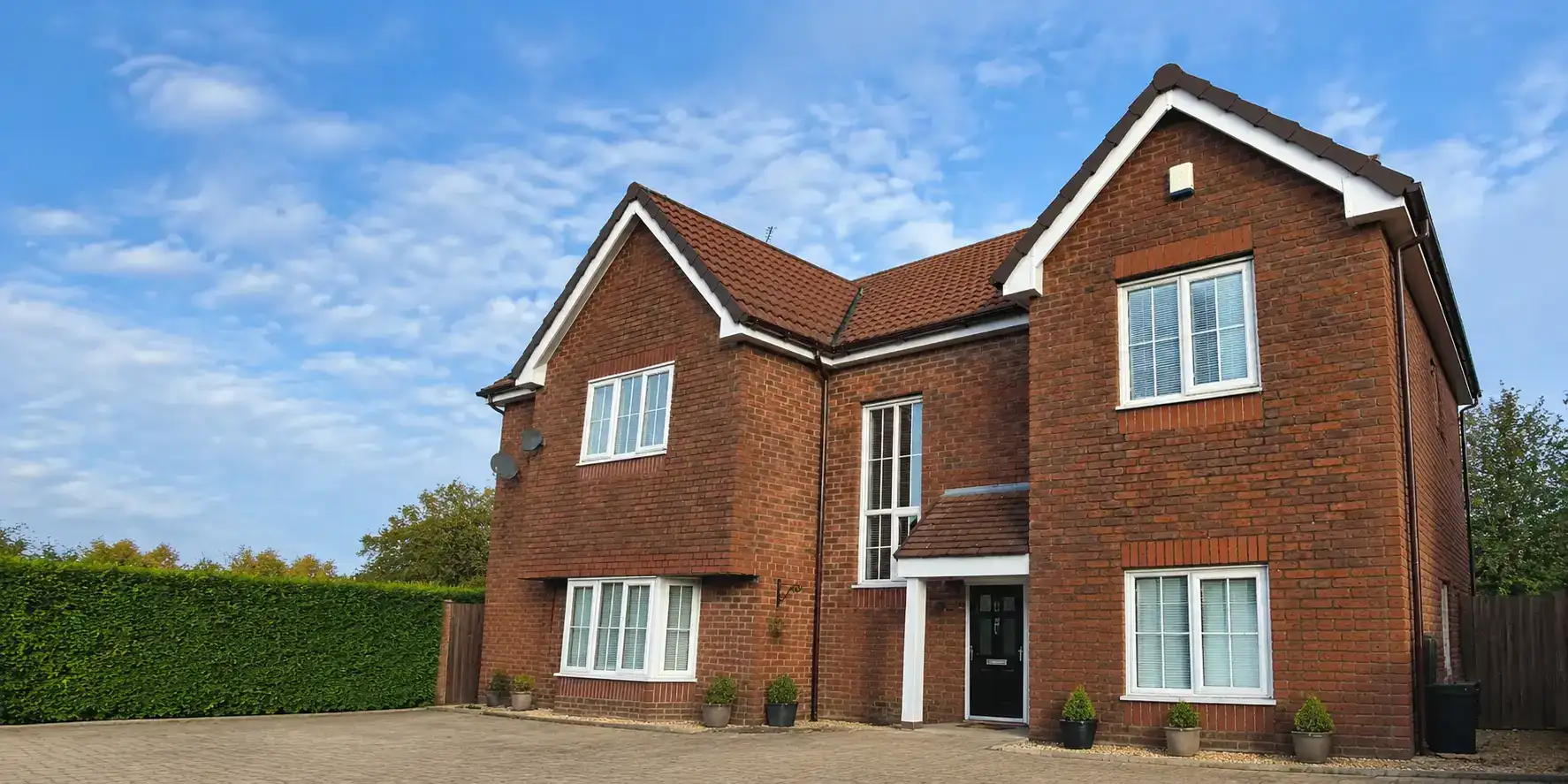 Red-brick North West home with white uPVC windows and roofline, featured in the installation gallery.