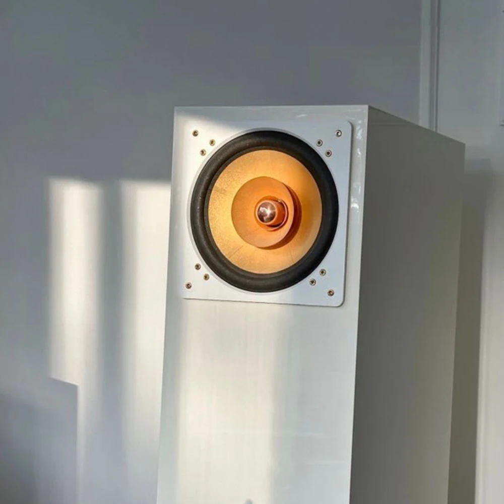 Enceinte Cube Audio Nenuphar blanche avec son HP orange sur fond de mur blanc