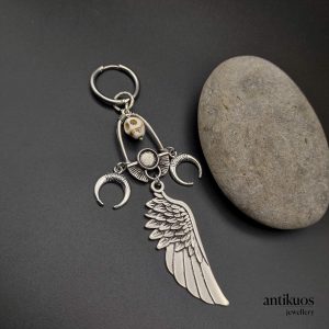 The sorcerer, large earring with a skull, moons and large angel wing