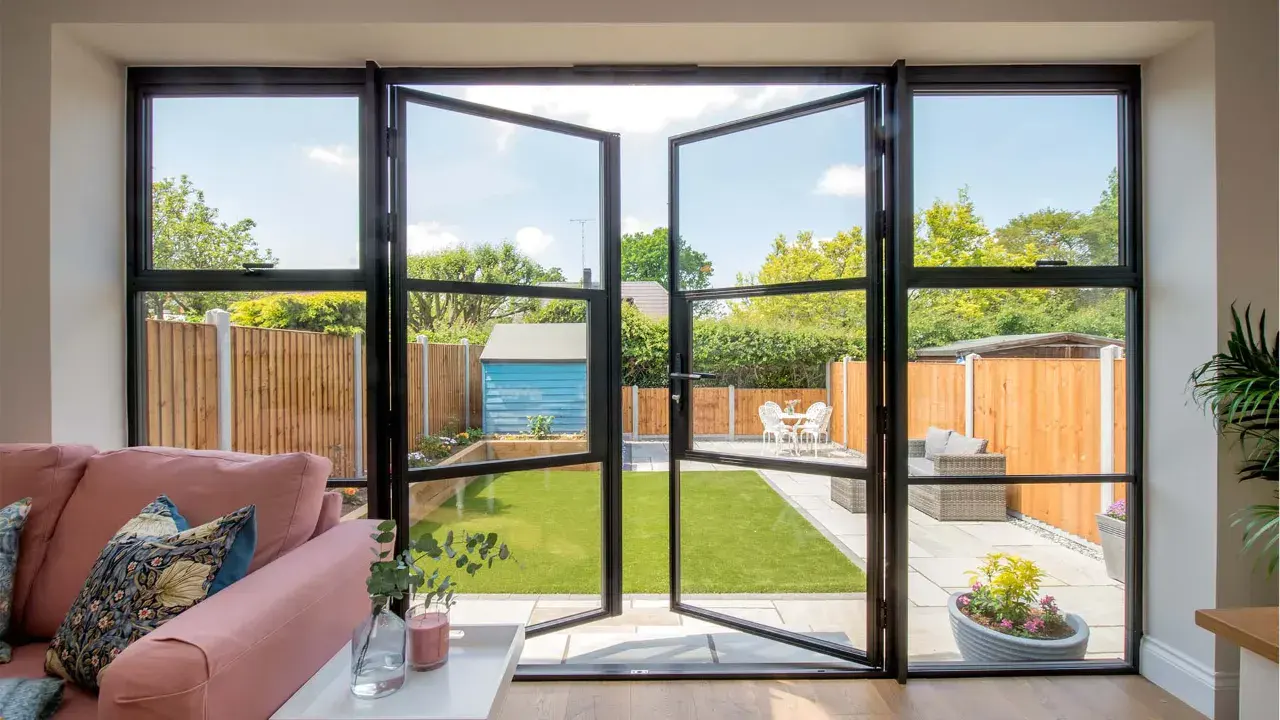 Decorio black aluminium bifold door open from living room to garden patio