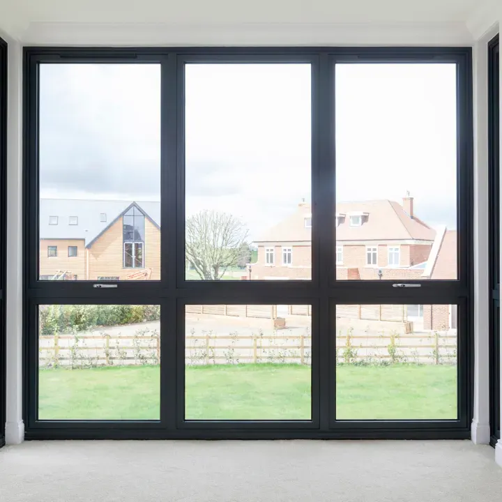 smart aluminium window with large anthracite frame overlooking garden and houses
