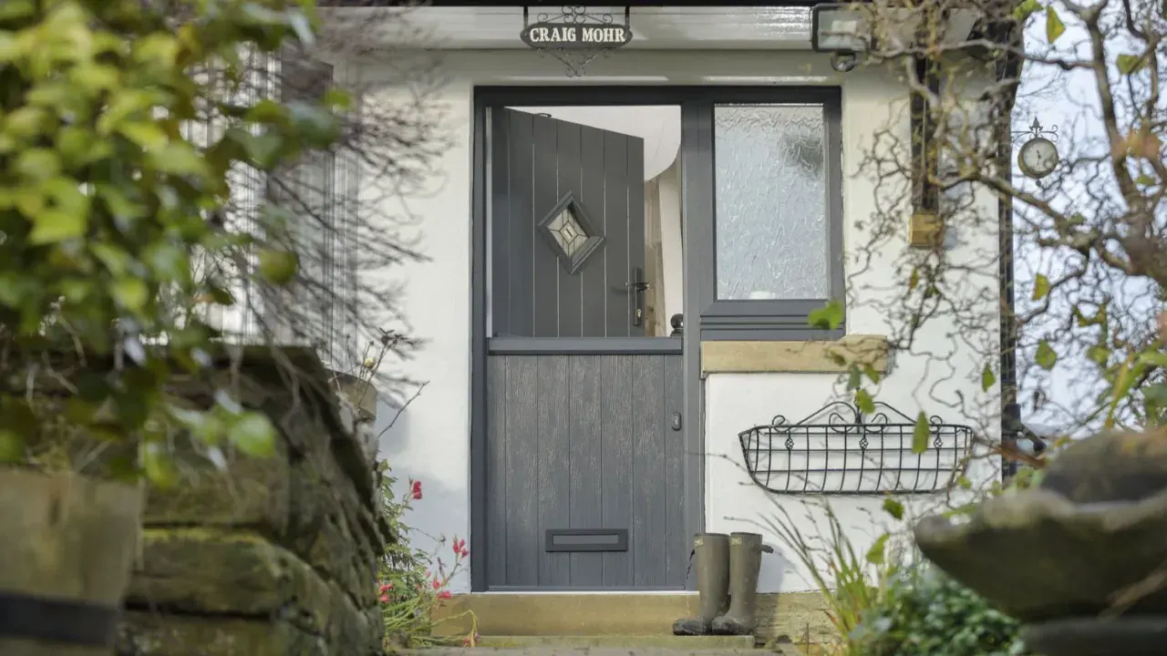 Solidor grey composite stable door with diamond glazing and side panel in cottage entrance
