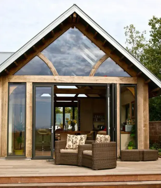 Black aluminium bifold doors fitted to an oak-framed garden room