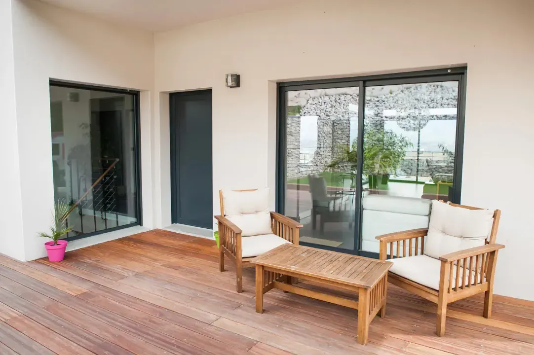 Black aluminium sliding patio doors opening onto a decked terrace