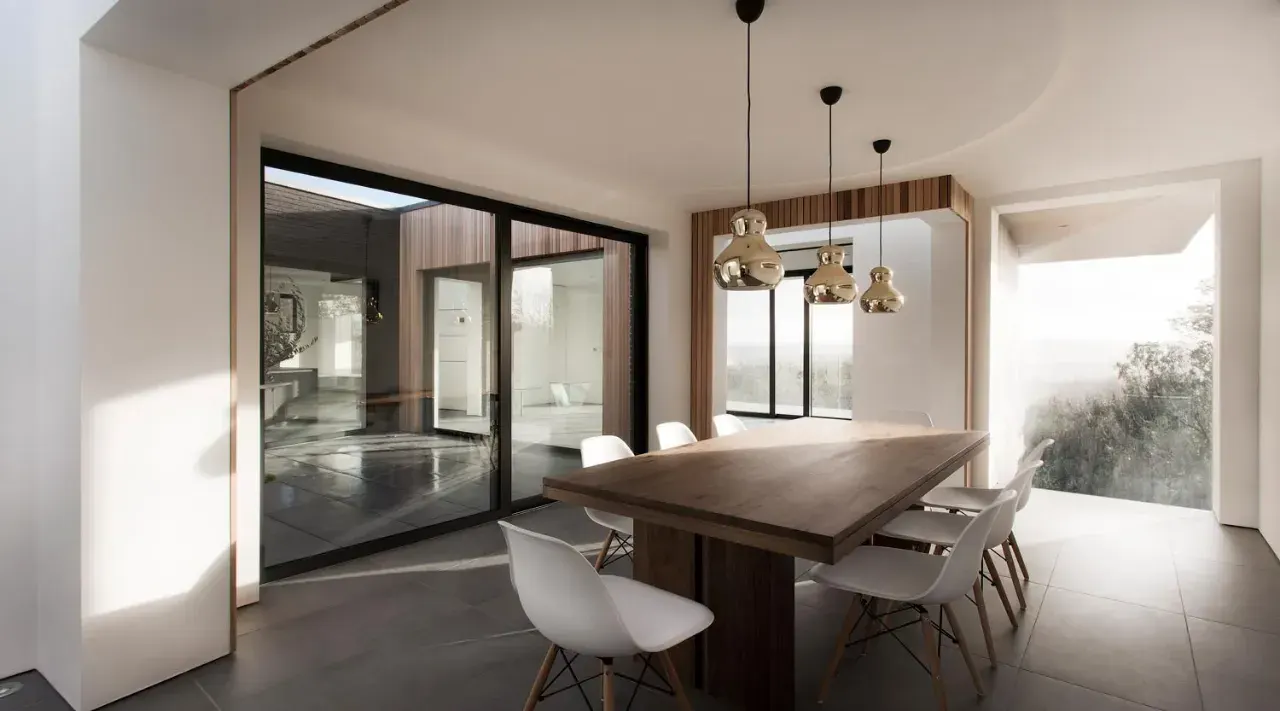Black aluminium sliding patio doors fitted beside a modern dining area