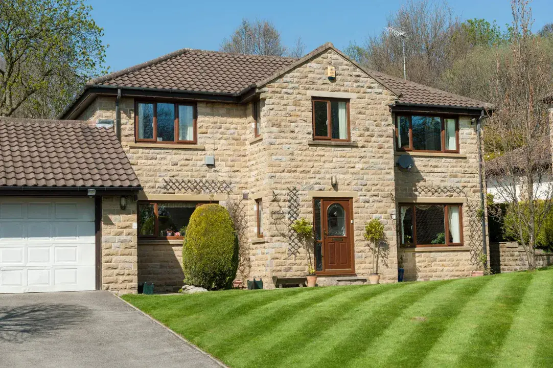 Brown uPVC casement windows fitted to a two-storey stone house