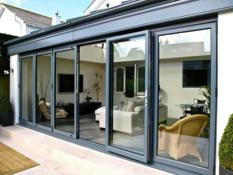 Grey aluminium bifold doors fitted to a conservatory extension