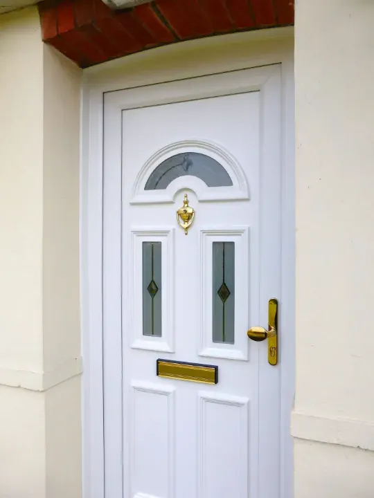 White uPVC entrance door with decorative glazing and gold hardware