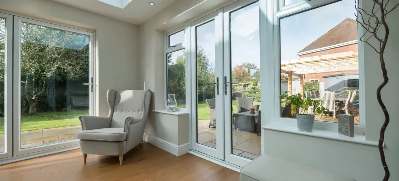 White uPVC French back doors opening from a garden room onto a patio