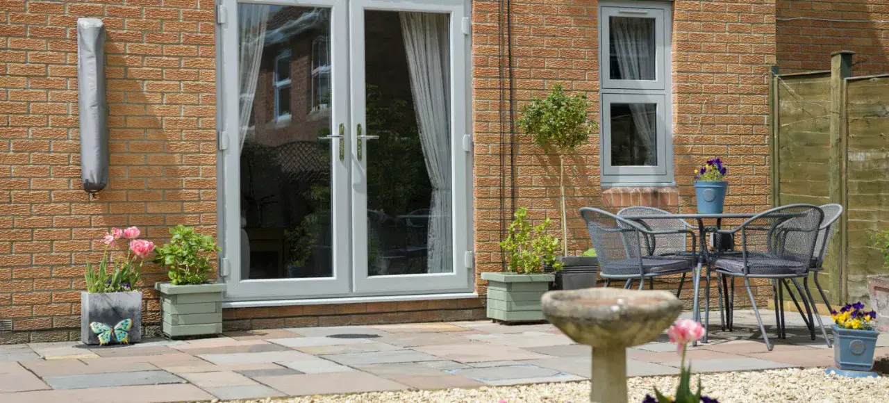 White uPVC French doors fitted to a brick home overlooking a patio