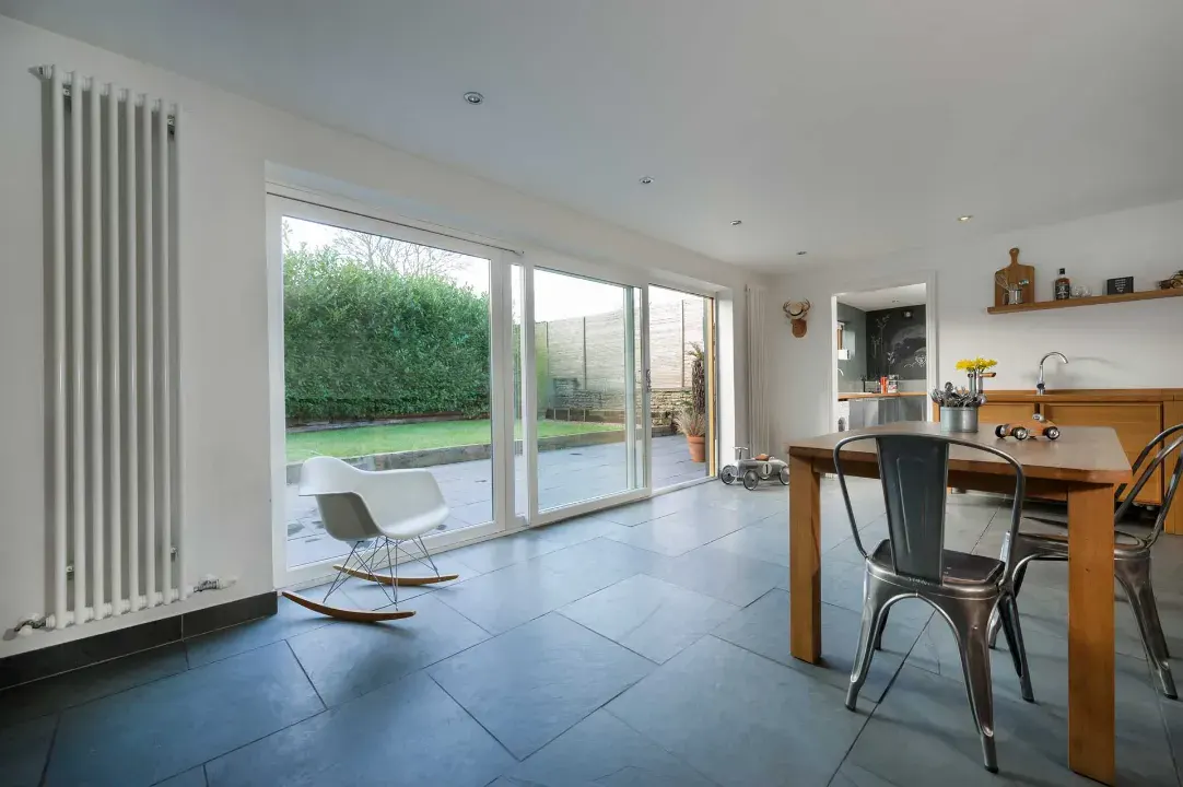 White uPVC sliding patio doors opening from an open-plan kitchen onto the garden