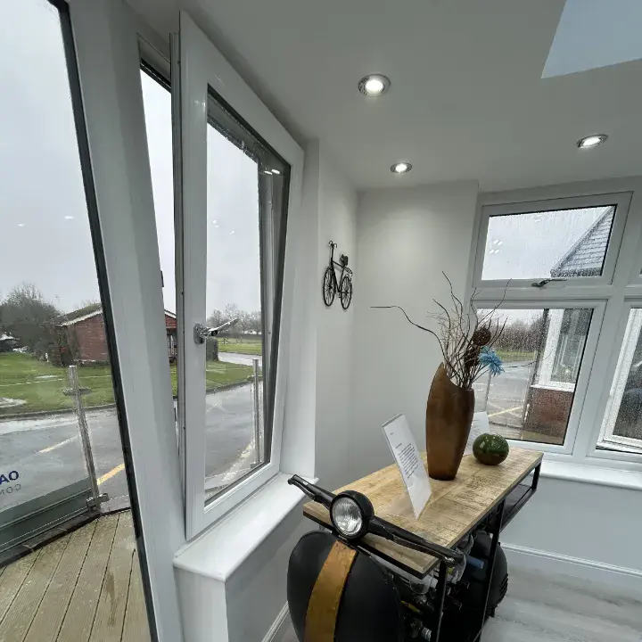White uPVC tilt and turn window opened inwards inside a modern room