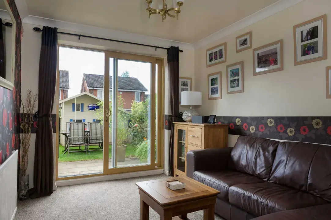 Wood-effect uPVC sliding patio doors opening from a living room onto the garden