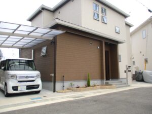 石目調タイルの門柱とアールの花壇で柔らかな印象の新築外構