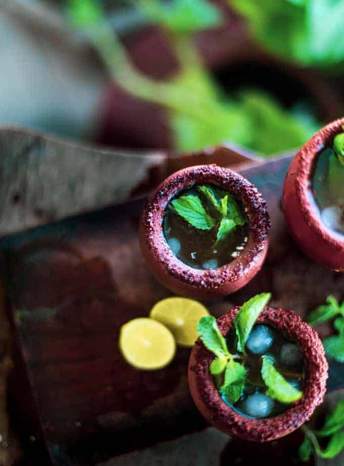 Tamarind Margarita with mint sprigs, lemon in terracotta glasses