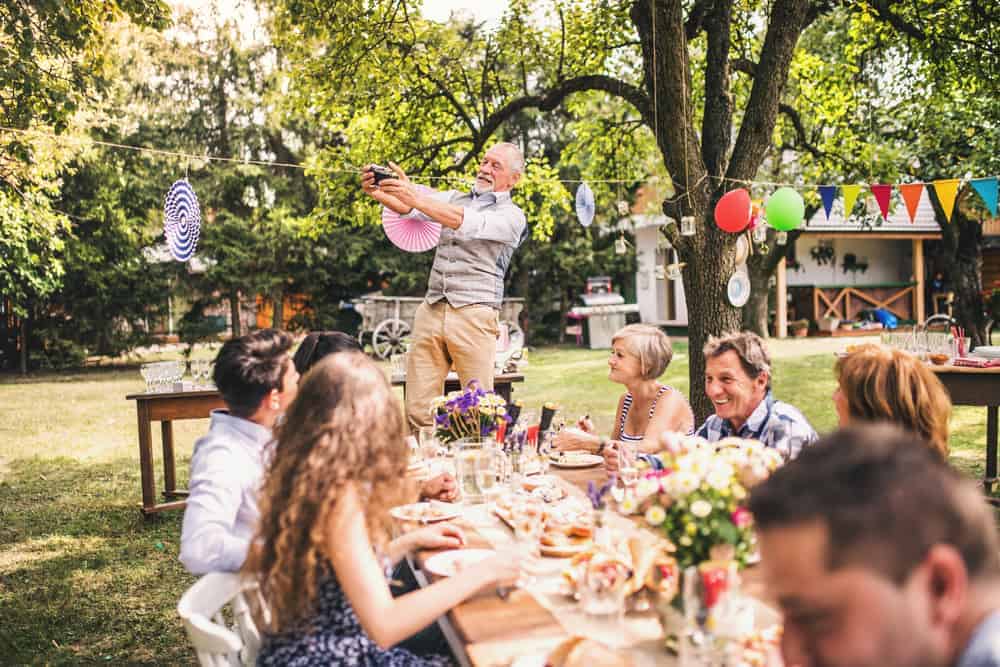 A family enjoying a party in the garden with colourful balloons