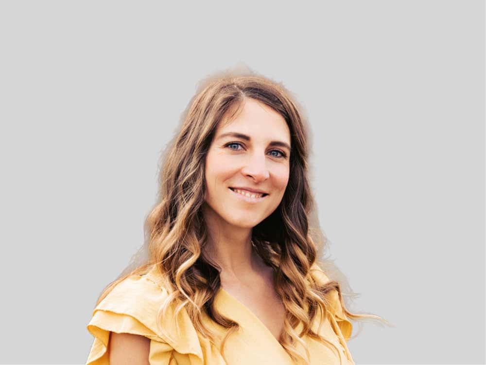 junge Frau mit gelbem Oberteil und langen Haaren