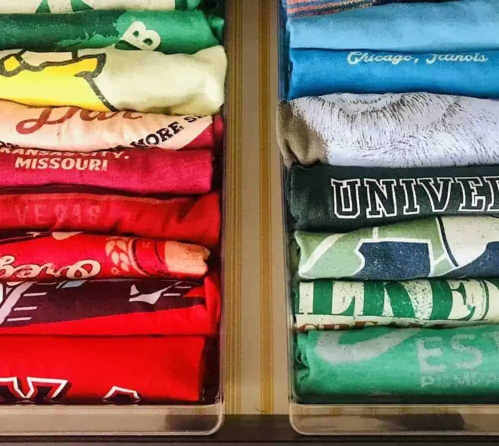 T-shirts file folded in clear drawer organizers and organized by color