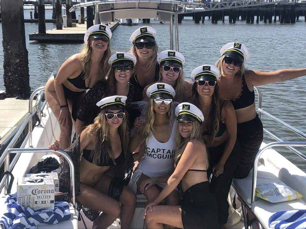 Group picture of women all wearing sunglasses and captains hat. Charleston bachelorette party boat