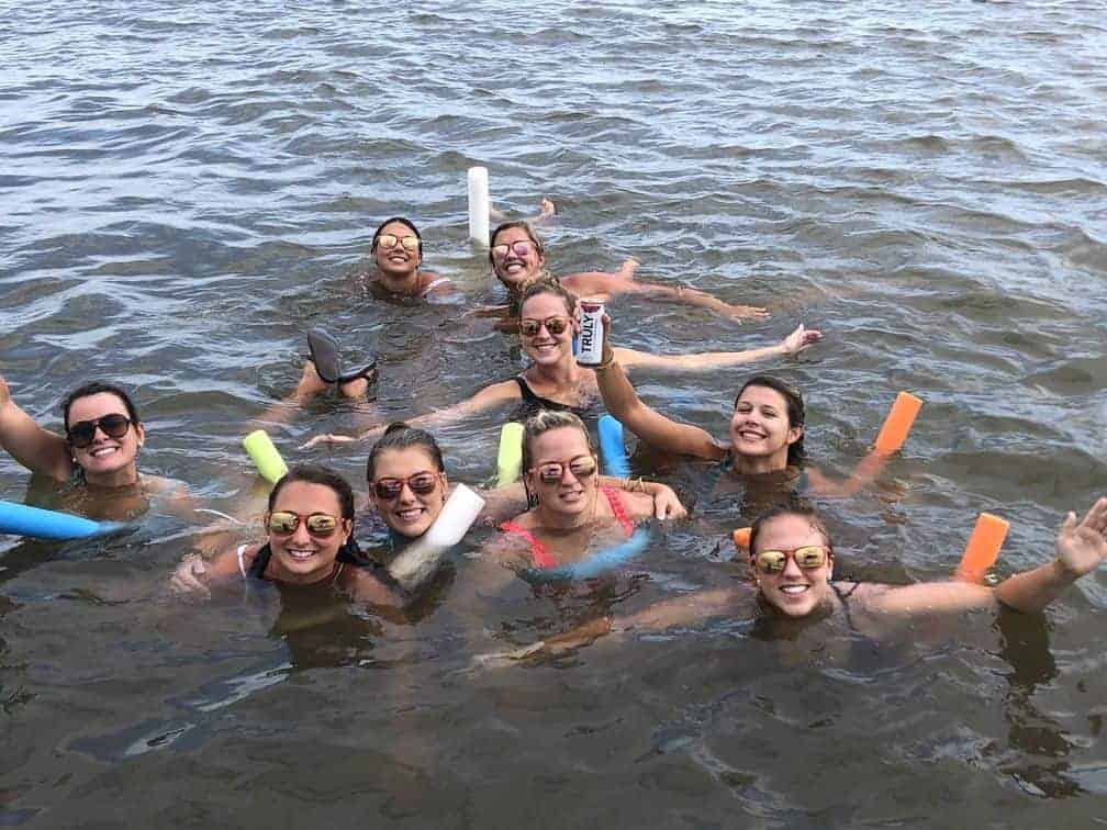 Women floating in the water on their pool noodles with their drinks. Charleston booze cruise bachelorette