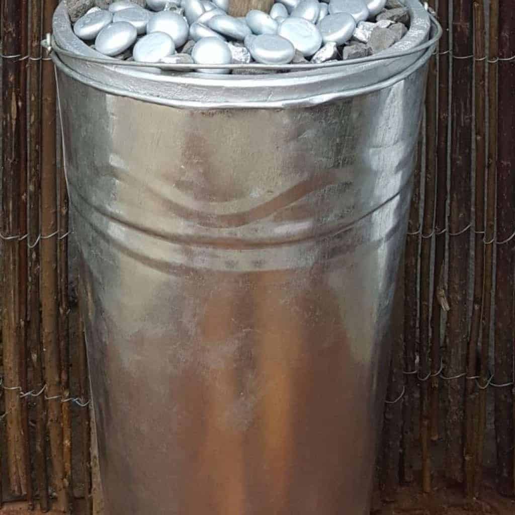 Fill a tall container with pebbles. #broomrepurpose #broomchristmastree #acraftymix #broomdecor #christmastree #DIYChristmasTree