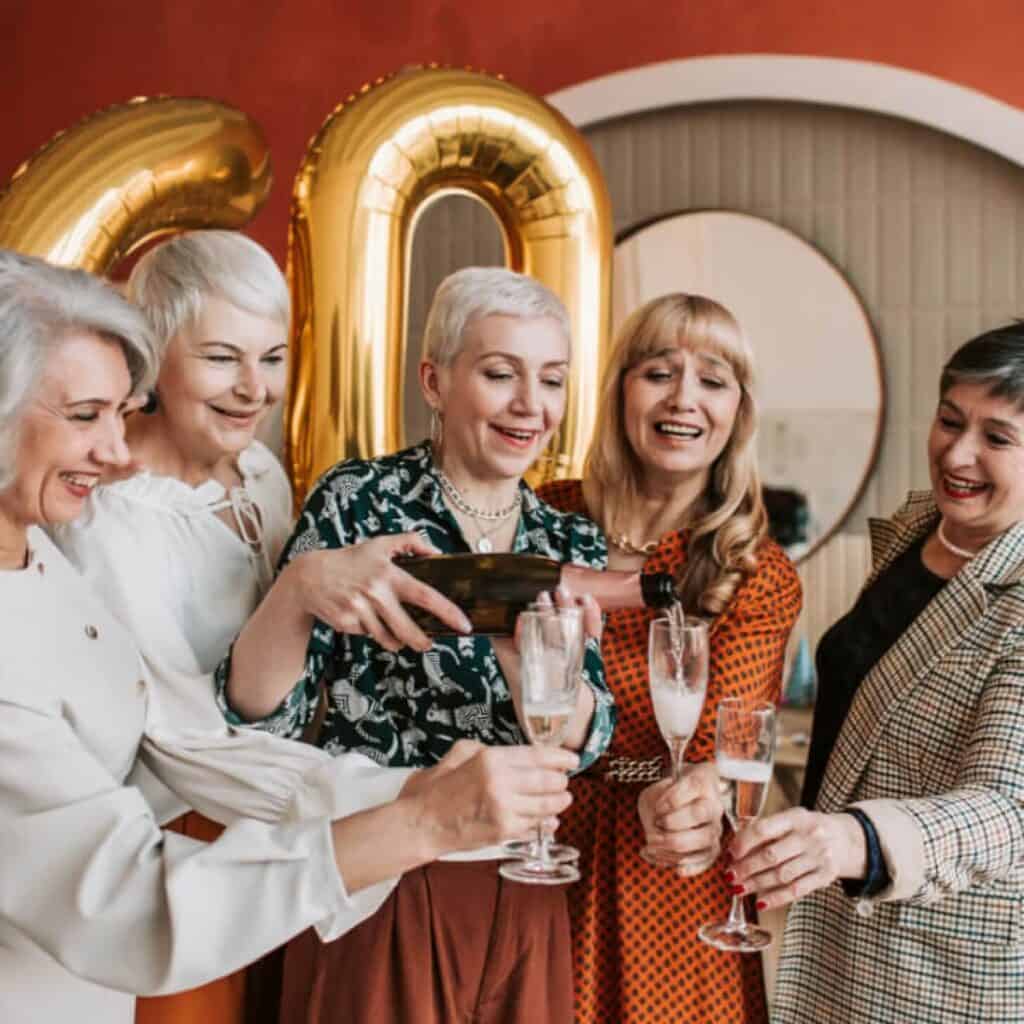 Older women pouring champagne into glasses