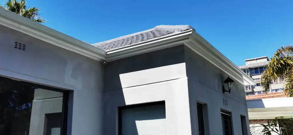 A modern seamless aluminium gutter system expertly fitted to a light grey residential exterior in the Western Cape.