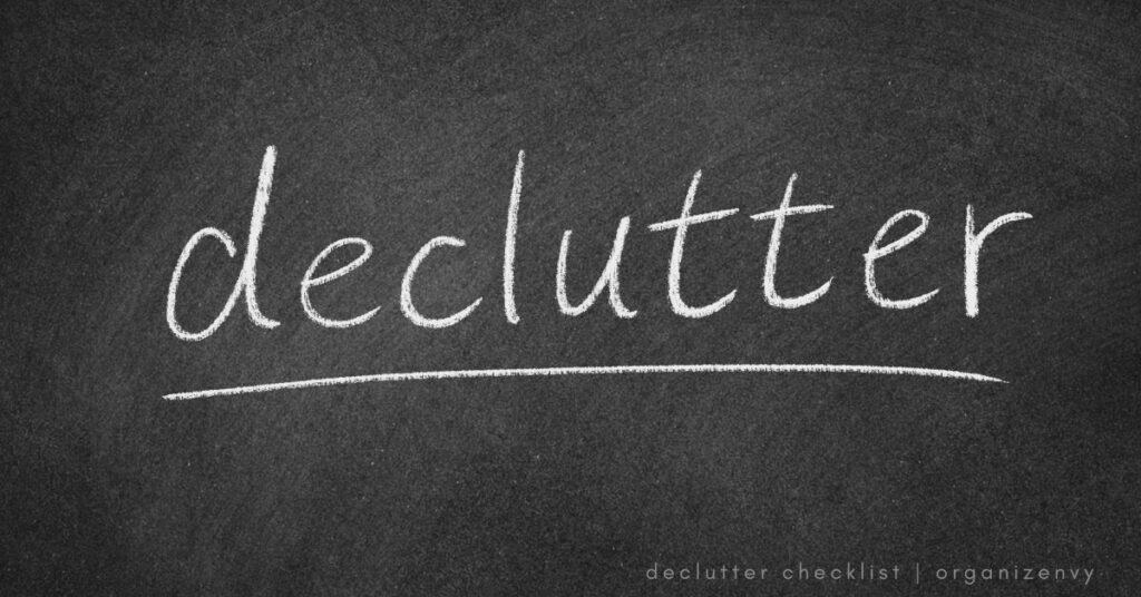 The word "declutter" is written in white chalk on a black chalkboard.