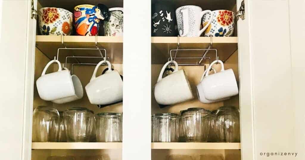 Mugs and cups on hooks in a kitchen cabinet