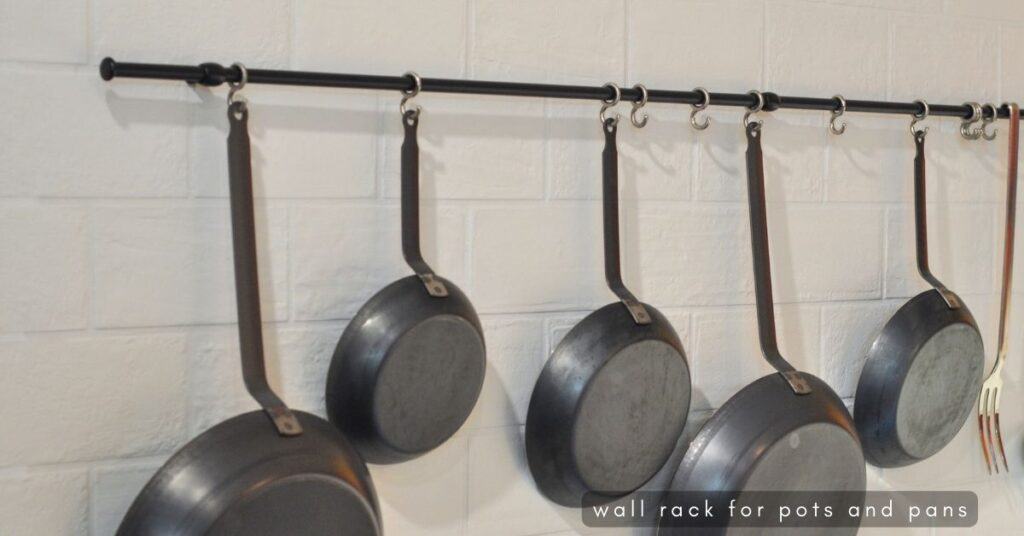 Pans hanging from a rack on a kitchen wall