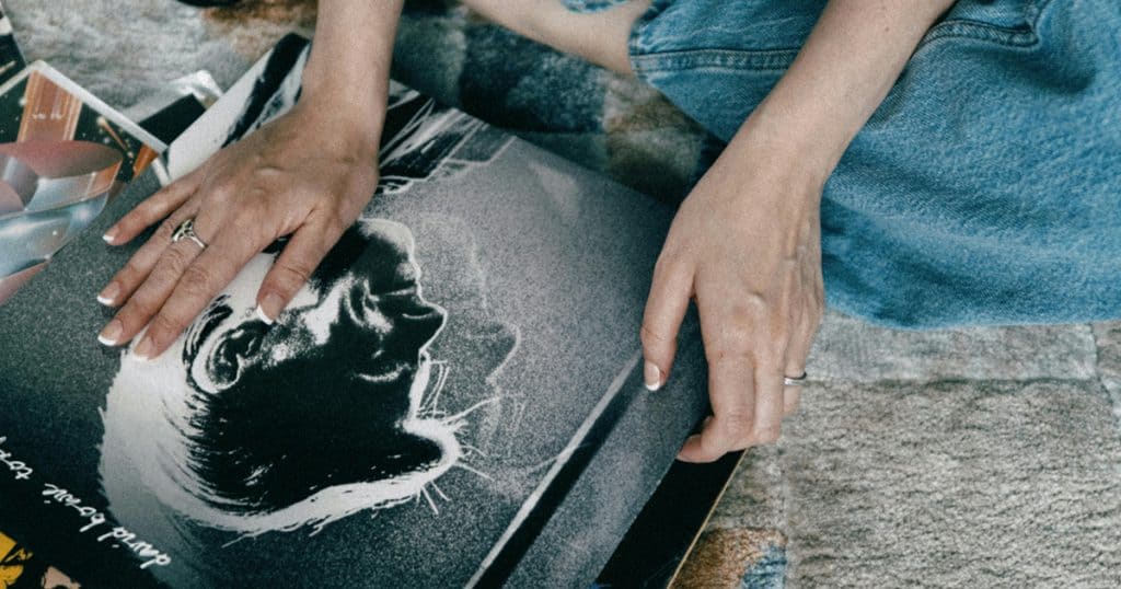 a person sitting with a record in hand