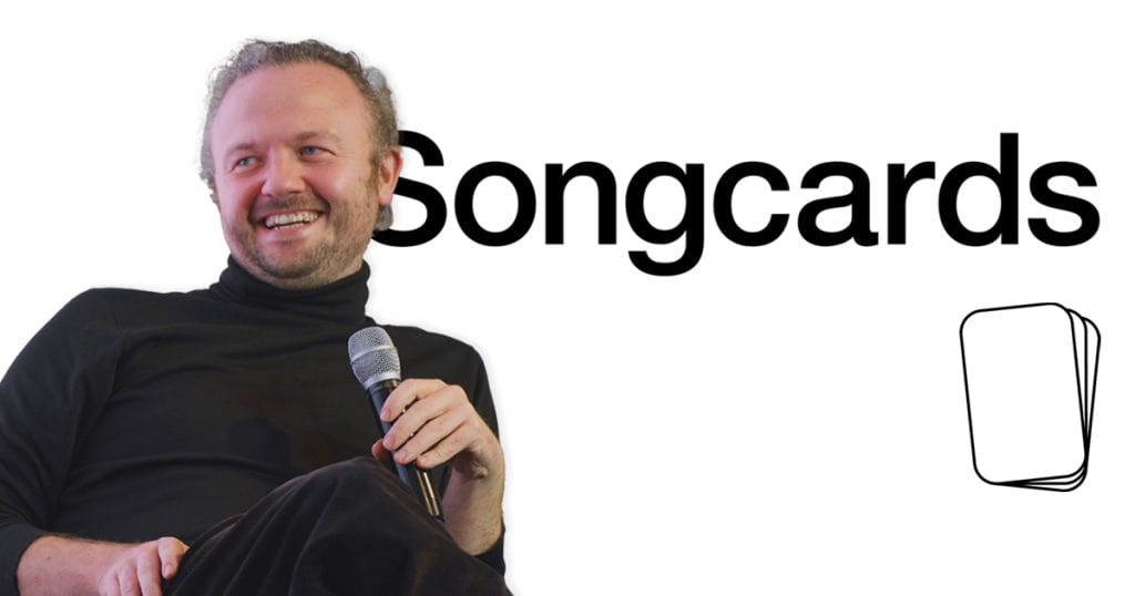 Creative musician holding a microphone at a Songcards event, promoting music streaming and digital music marketing solutions.