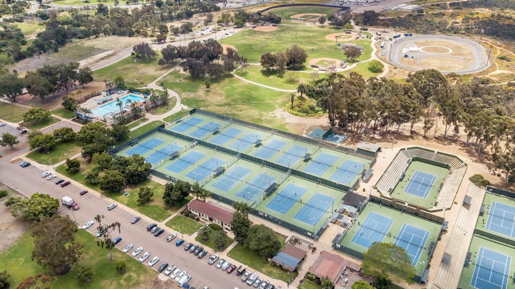 Elevated view of the Balboa Tennis Club at Morley Field in North Park, showing the expansive court layout, swimming pool, and surrounding parkland.
