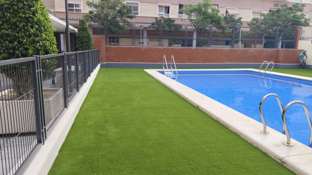 piscina con césped artificial en Alicante instalado profesionalmente por TaybGrass, siempre verde y de bajo mantenimiento