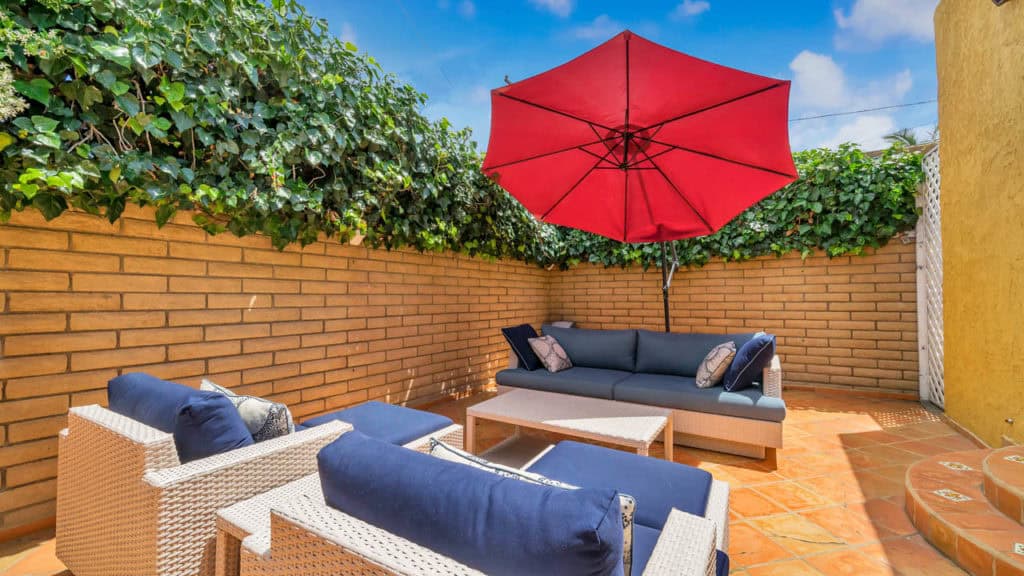 blue outdoor furniture with red umbrella in the backyard 