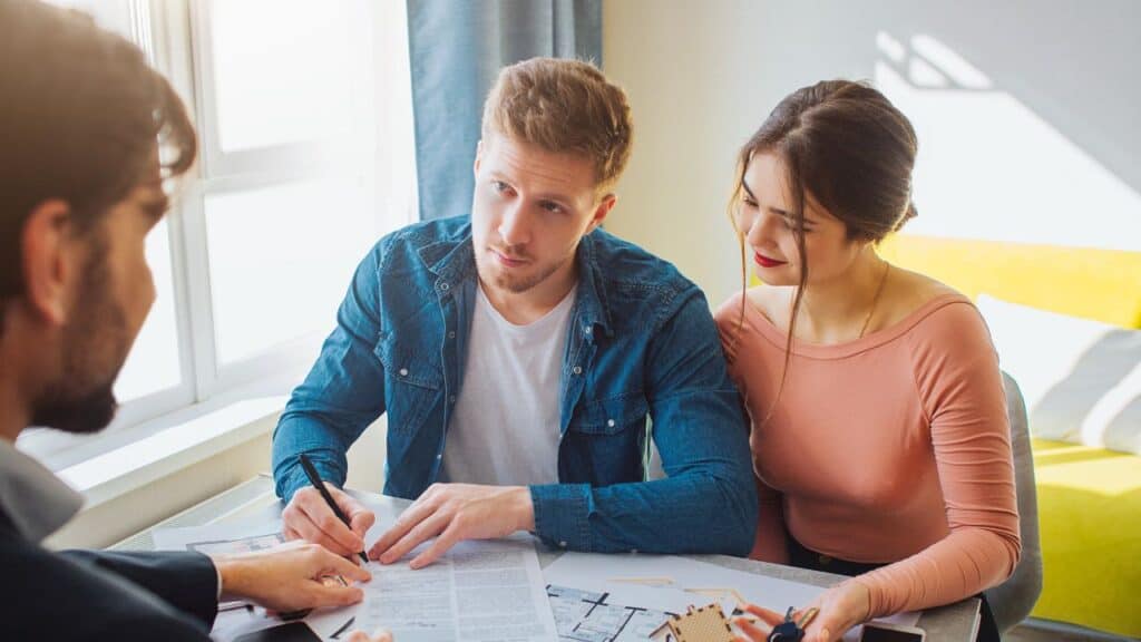 A Couple Talking to their Realtor while Explaining Documents