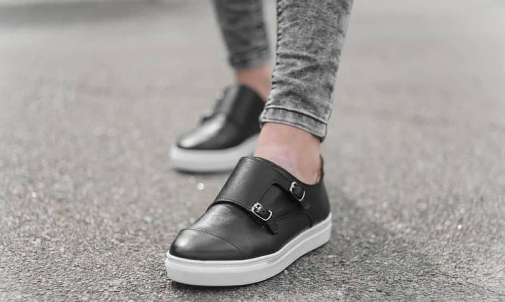 person in gray denim jeans wearing black and white nike sneakers
