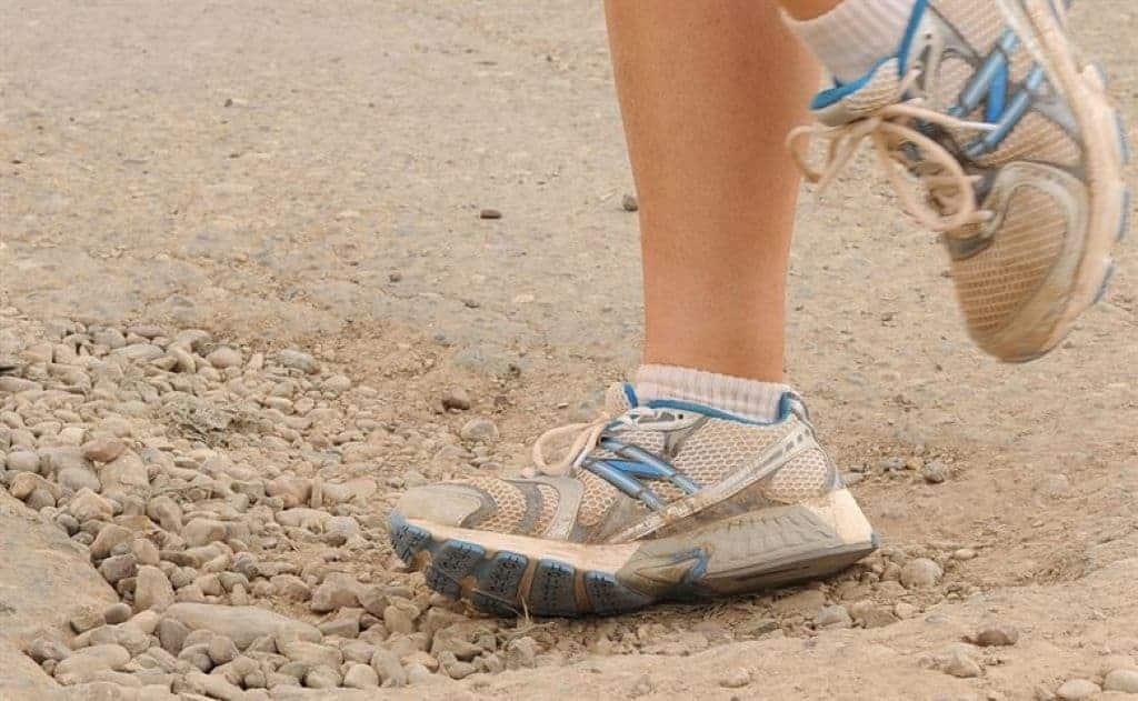 running shoes uneven pavement littered with potholes and rocks