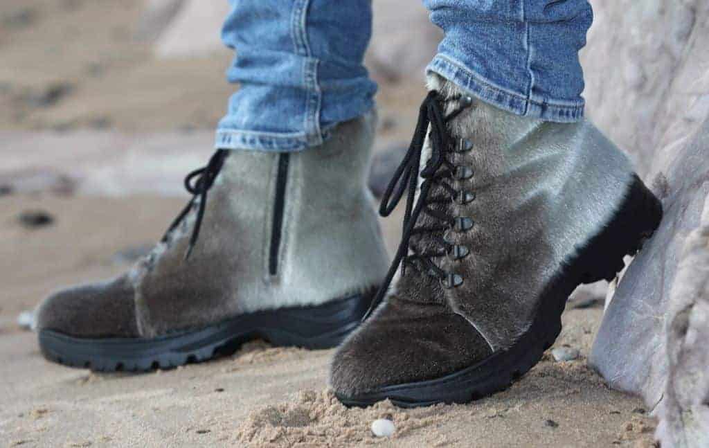 person on grey boots and blue jeans