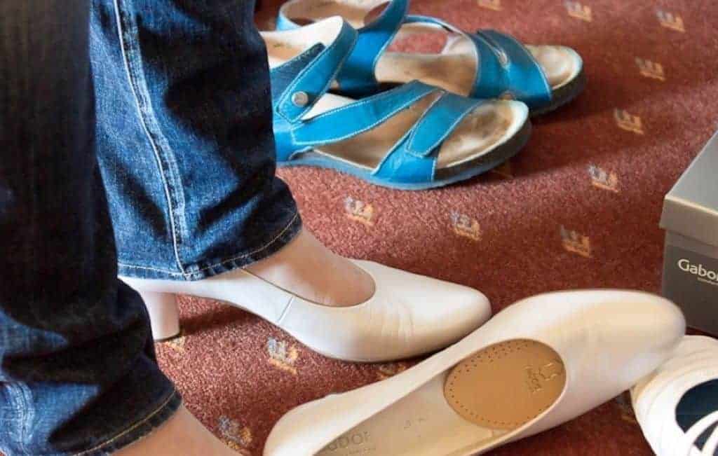 women fitting a white shoe and blue shoe