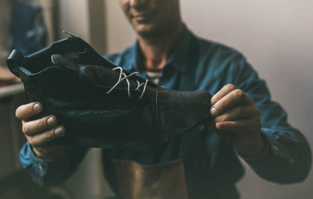 man looking at a leather boot