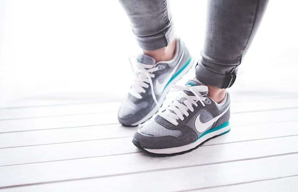 person wearing gray and white Nike running shoes