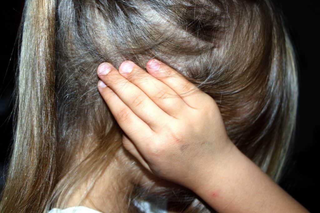 Niña tapándose las orejas