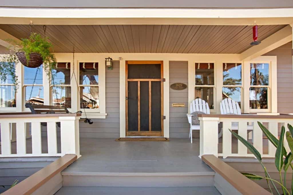 Charming Craftsman home porch at 3629 Utah Street in North Park, featuring a classic wood screen door, white railings, and a hanging porch swing.
