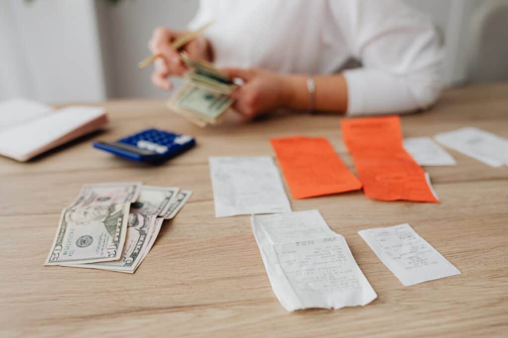 A Person Budgeting in a Table and Paying Her Bills