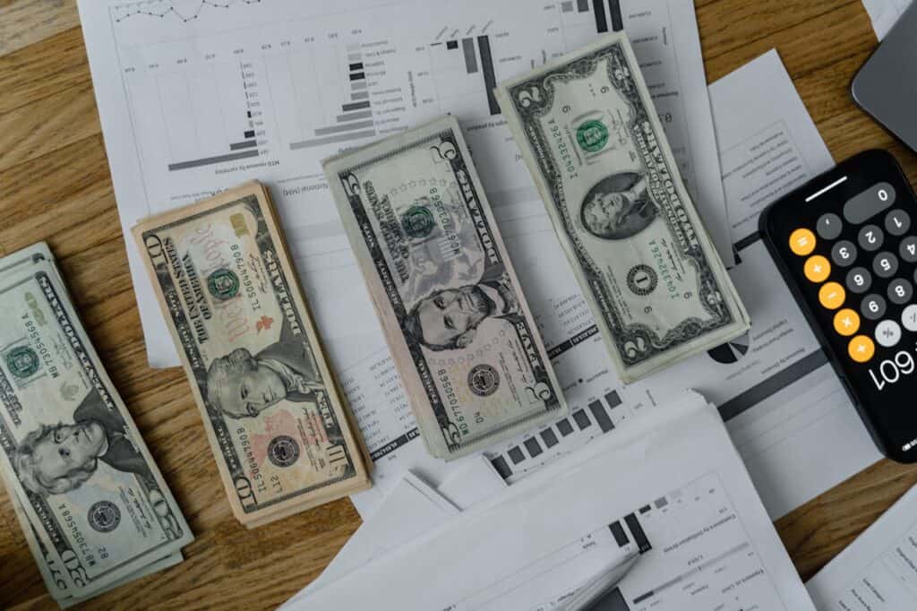 A Bunch of Dollars Separated into Segments in a Brown Table